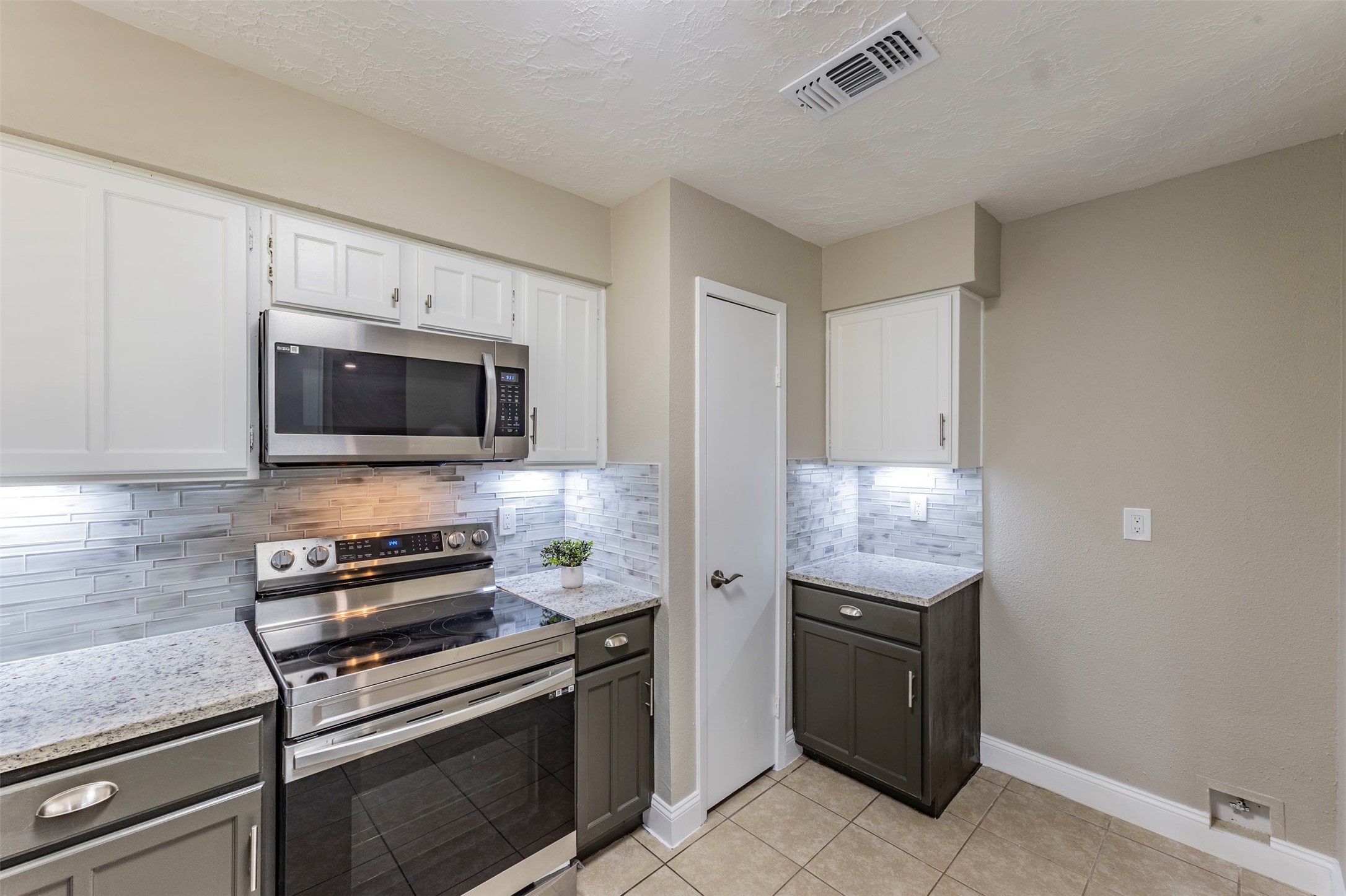 21022 Waymare Lane Spring, TX 77388 - Photo 5 of 29 a kitchen with granite countertop a stove and a microwave