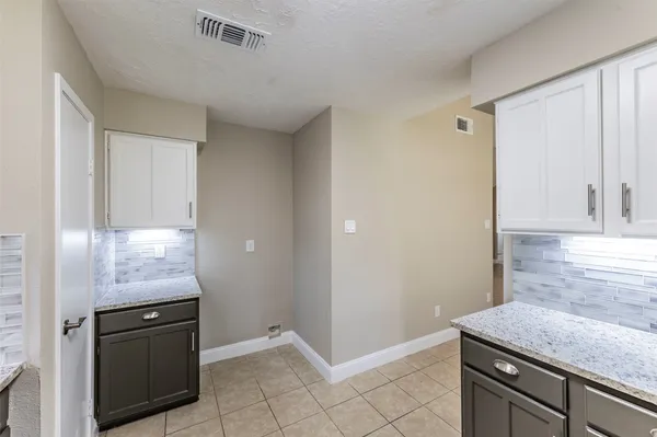 a kitchen with granite countertop white cabinets and white appliances