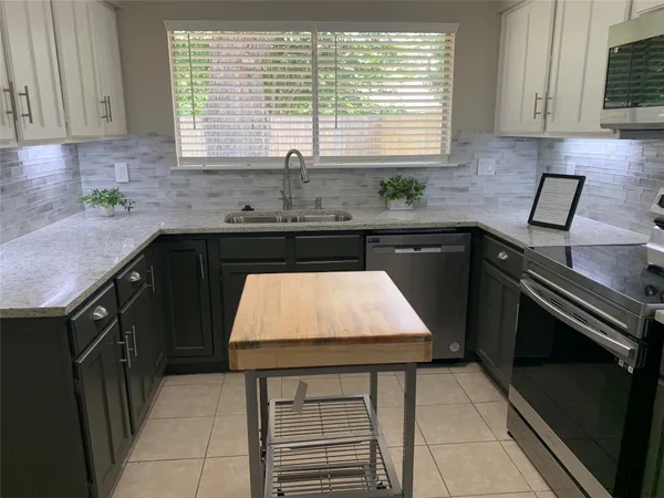 a kitchen with a sink a stove and cabinets