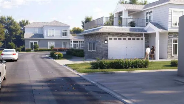 a front view of a building with garden and parking