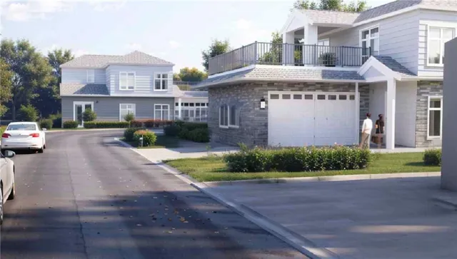 a front view of a building with garden and parking