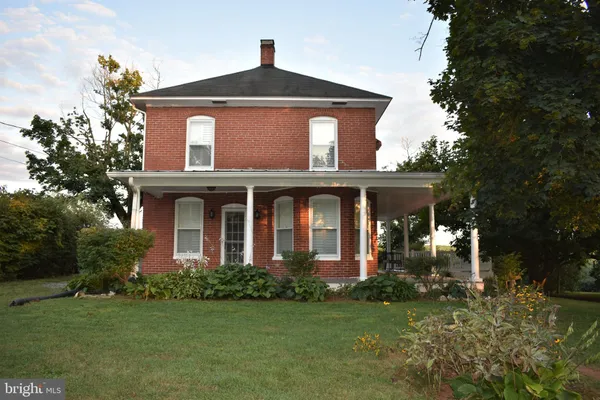 a view of a house with a big yard and large trees