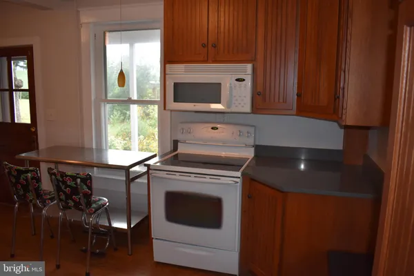 a kitchen with stainless steel appliances a refrigerator stove and wooden floor