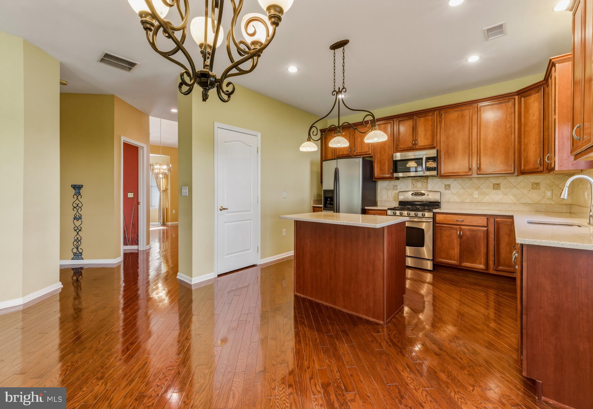 106 York Road West Deptford, NJ 08086 - Photo 9 of 31 a kitchen with stainless steel appliances granite countertop a refrigerator a sink dishwasher a stove and a dining table with wooden floor