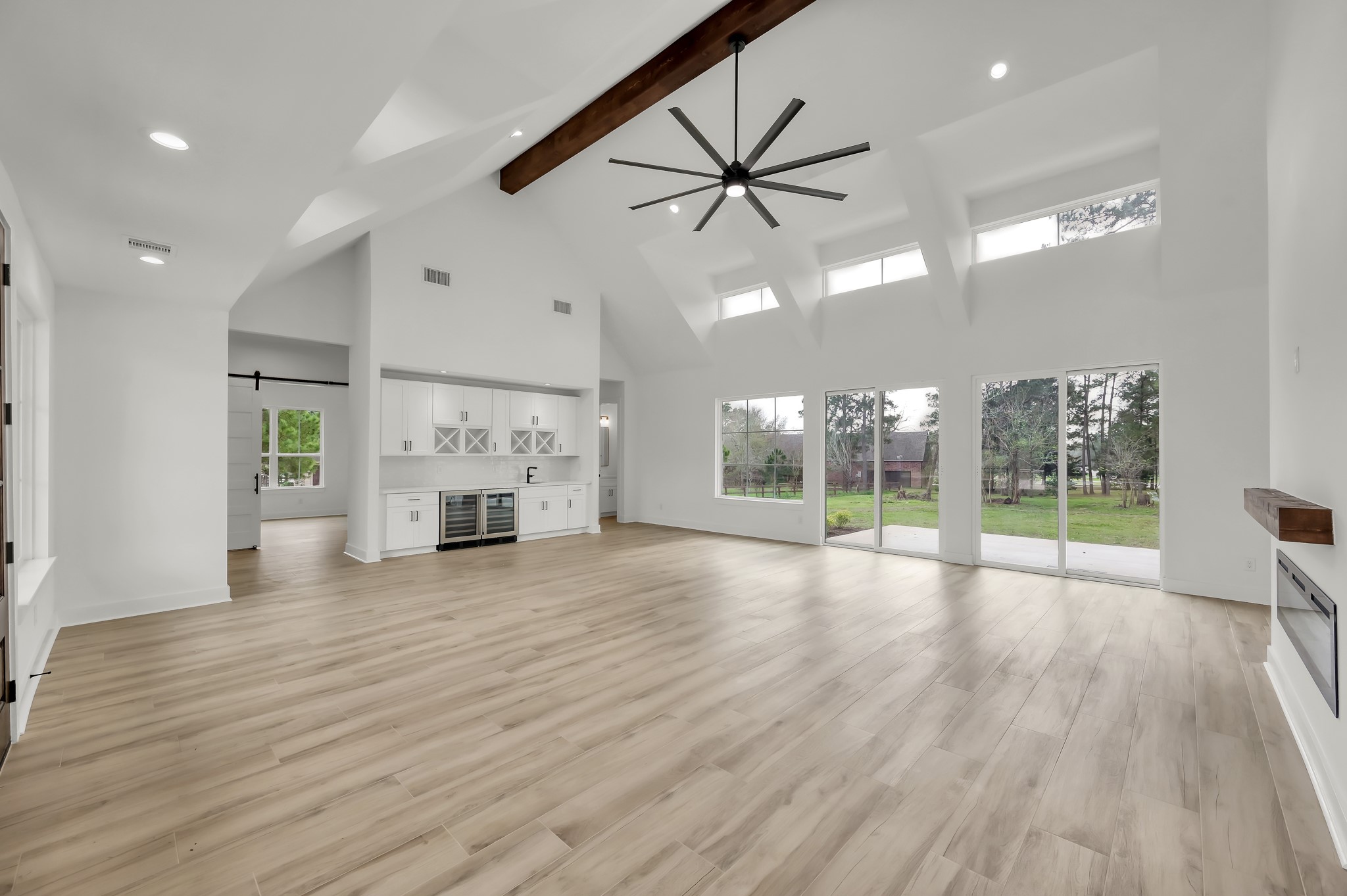 14742 Turquoise Trail Willis, TX 77378 - Photo 5 of 48 Open-concept living room designed for both entertaining and everyday comfort, featuring high ceilings, large windows, and seamless flow to the outdoor living space.