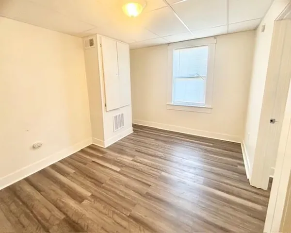 a view of a room with wooden floor and white walls