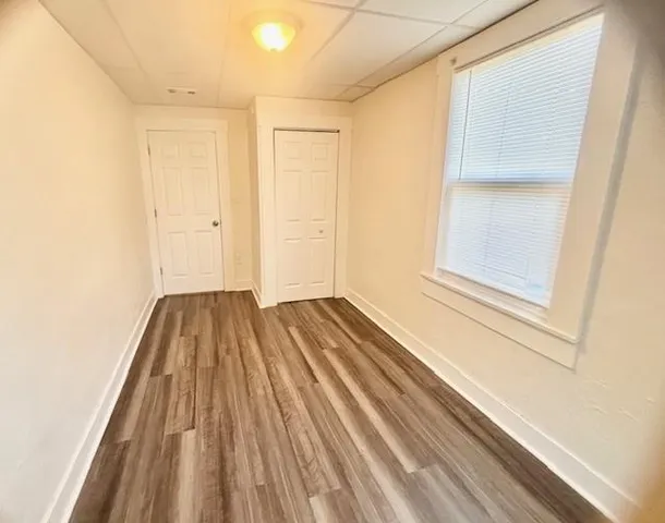 a view of a room with wooden floor and bench