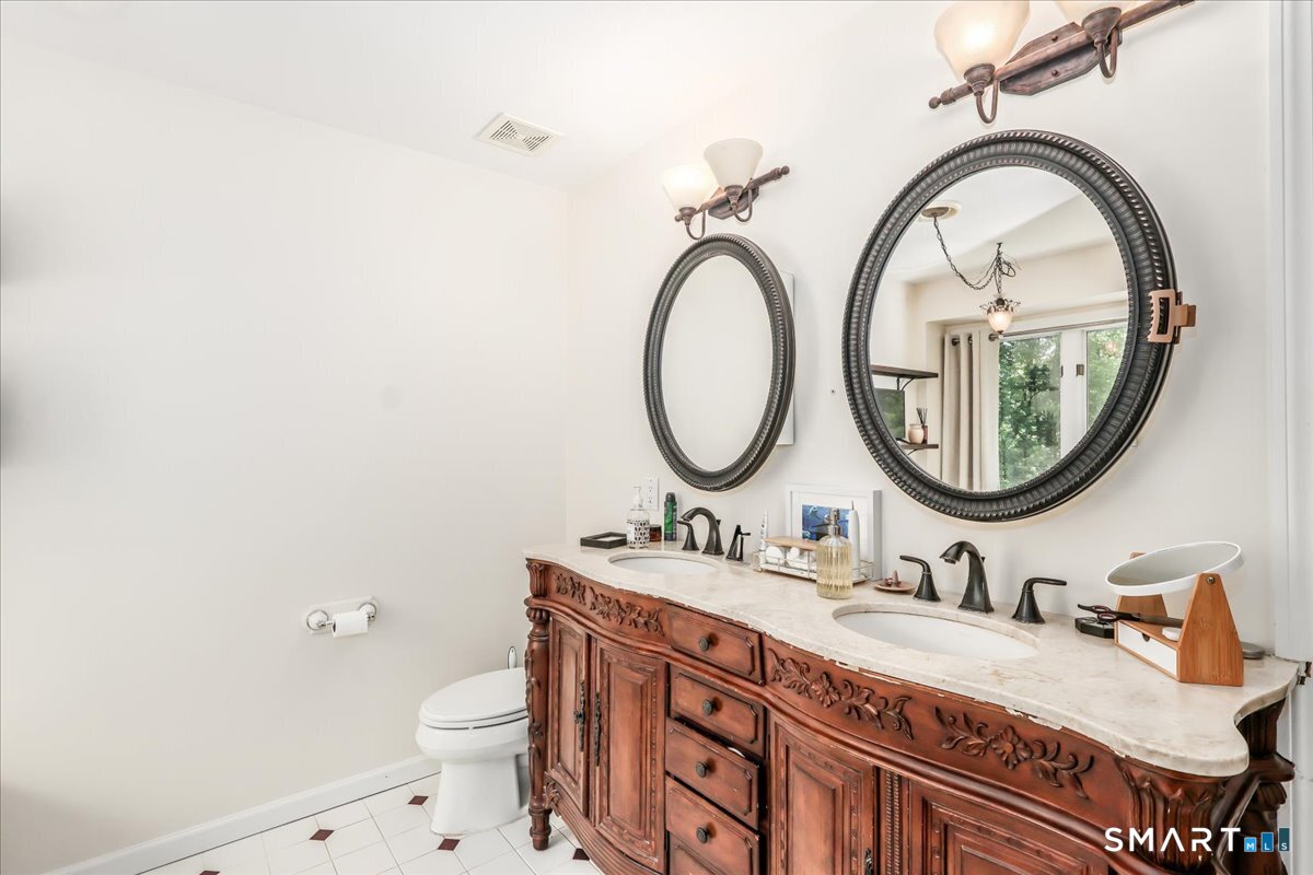 55 A Flax Hill Road Brookfield, CT 06804 - Photo 29 of 40 a bathroom with a granite countertop toilet a sink and a mirror