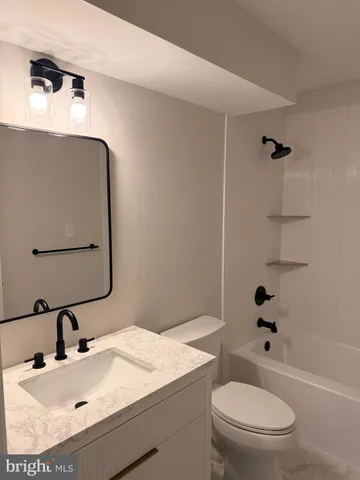 a bathroom with a sink toilet vanity and shower