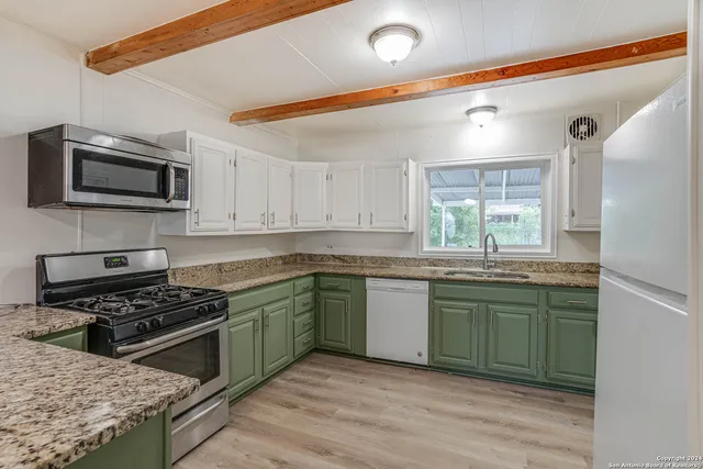 a kitchen with stainless steel appliances granite countertop a stove a sink and a microwave