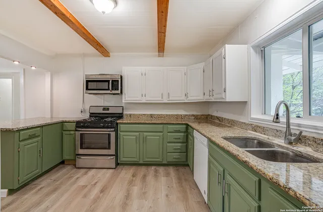 a kitchen with stainless steel appliances granite countertop a sink stove and cabinets