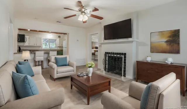a living room with furniture a fireplace and a flat screen tv