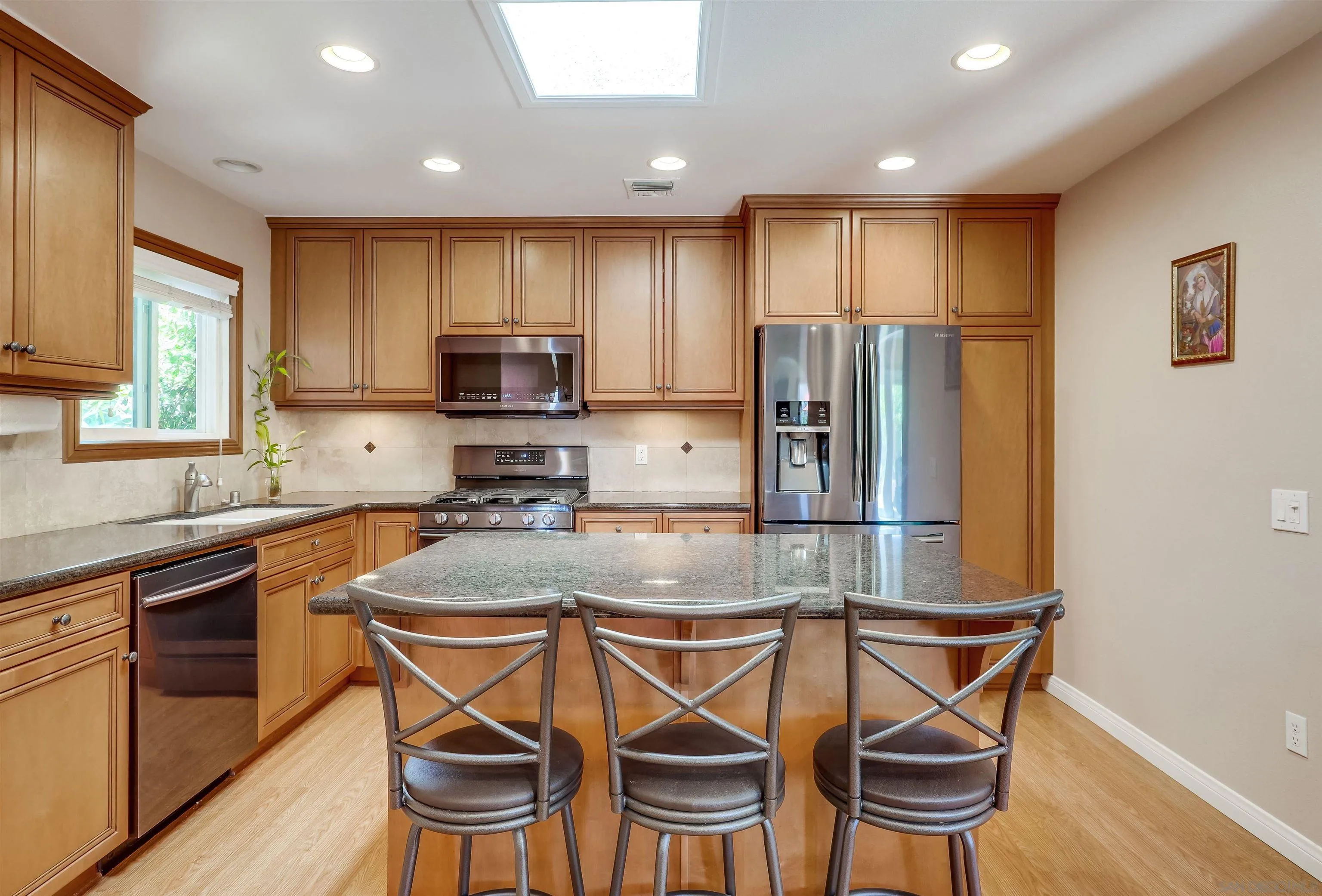 14039 Hermosillo Way Poway, CA 92064 - Photo 3 of 31 a kitchen with kitchen island a dining table and chairs