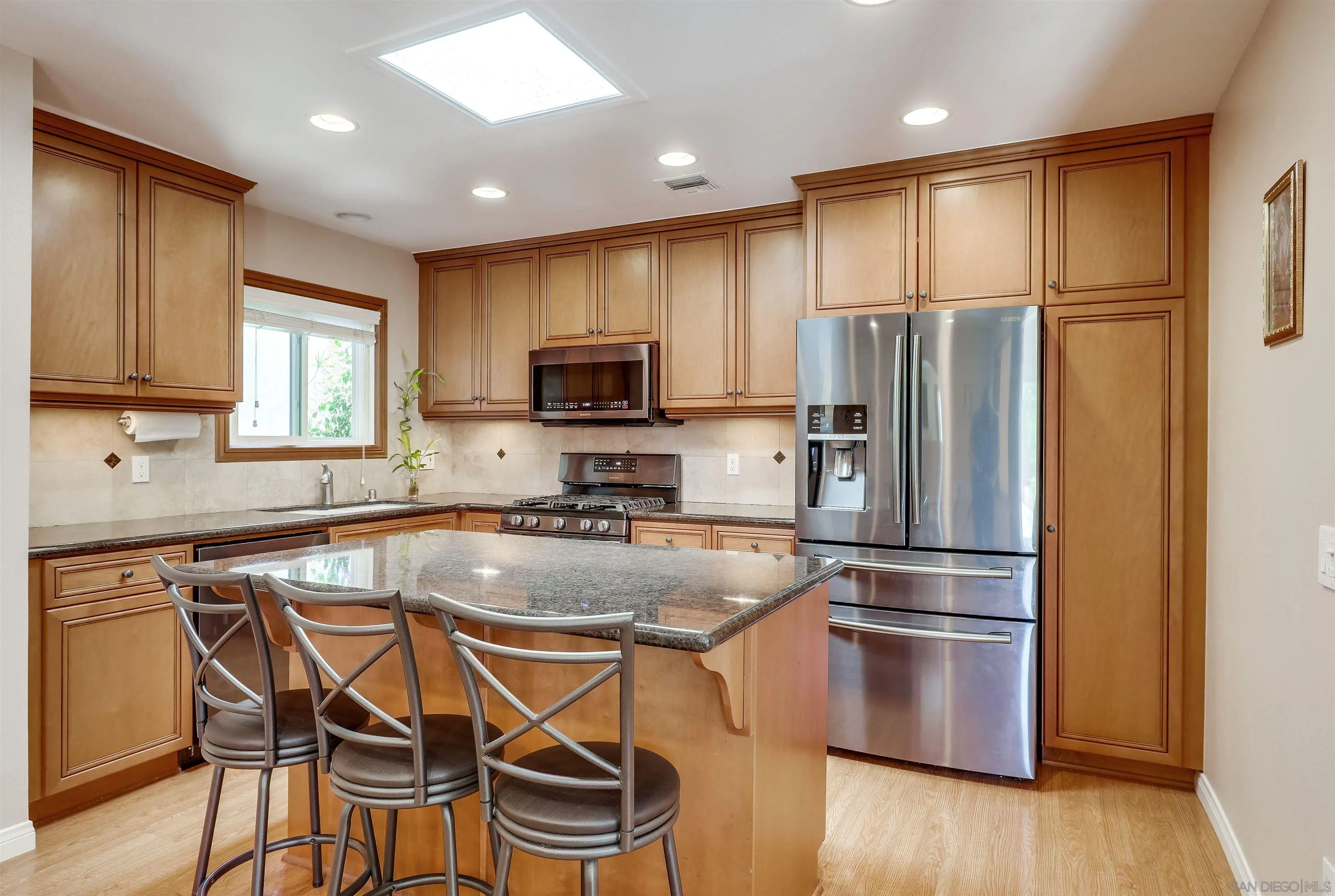 14039 Hermosillo Way Poway, CA 92064 - Photo 4 of 31 a kitchen with kitchen island a refrigerator stove microwave and sink