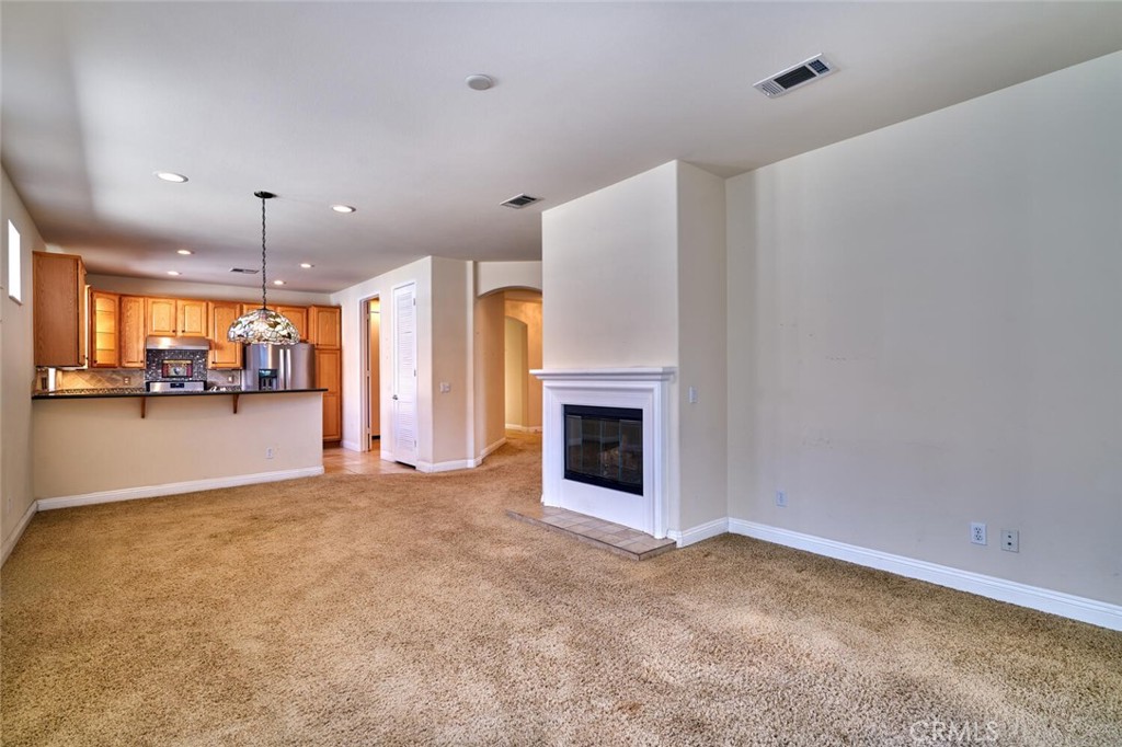 1143 Saguara Road Beaumont, CA 92223 - Photo 36 of 66 a view of an empty room with a fireplace and a window