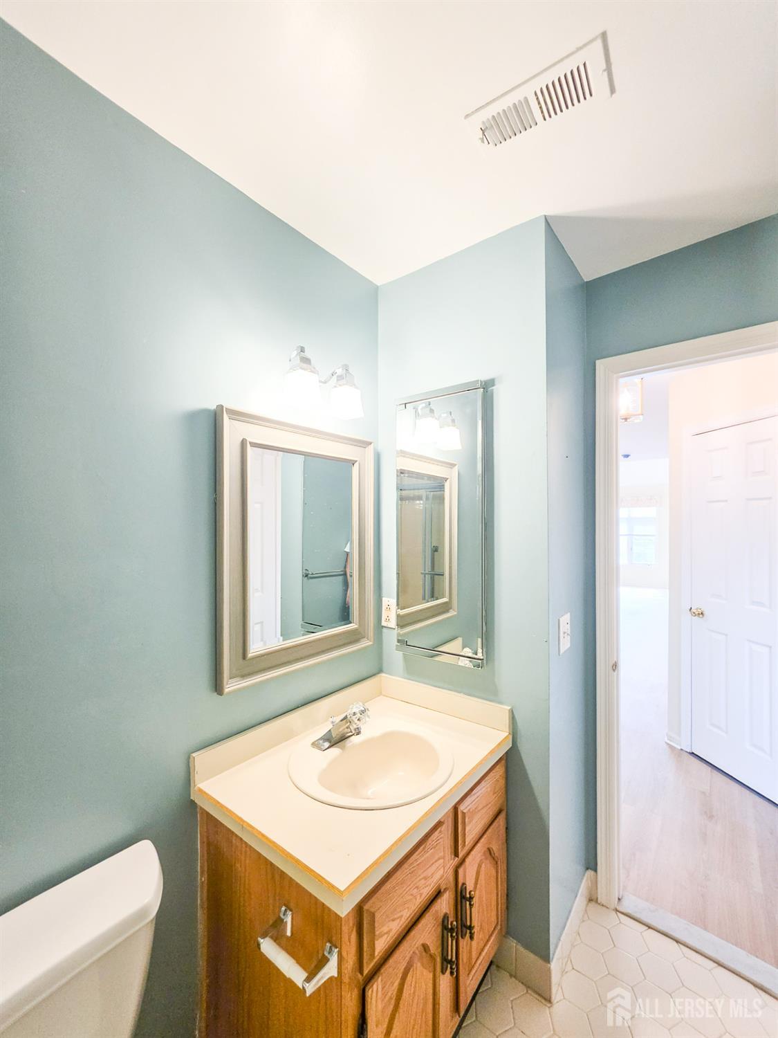1 H Rutland Lane Monroe Township, NJ 08831 - Photo 11 of 26 a bathroom with a sink a toilet and mirror