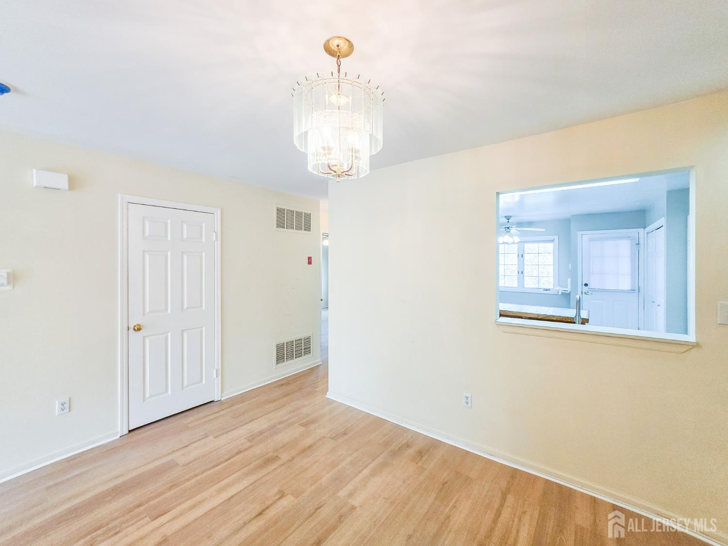 1 H Rutland Lane Monroe Township, NJ 08831 - Photo 17 of 26 a view of a room with wooden floor and chandelier