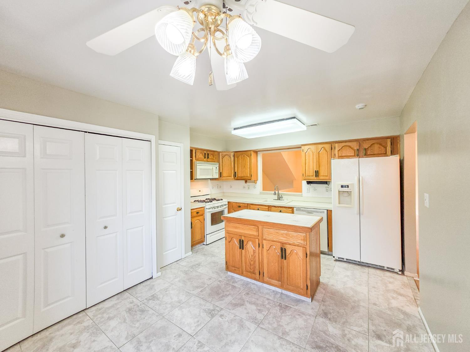 1 H Rutland Lane Monroe Township, NJ 08831 - Photo 4 of 26 a large kitchen with a stove a refrigerator and chandelier