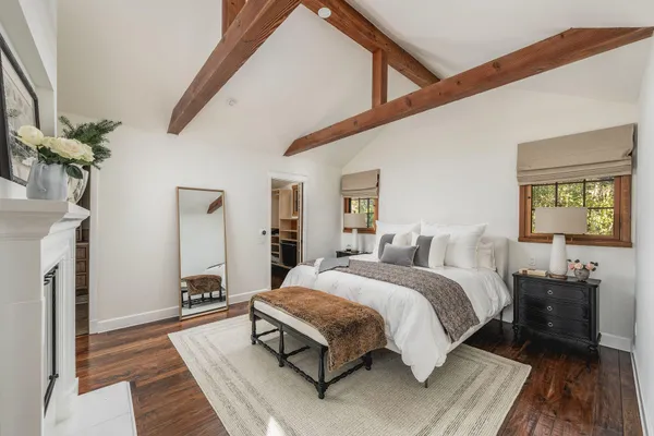 a bedroom with a bed table and a chandelier