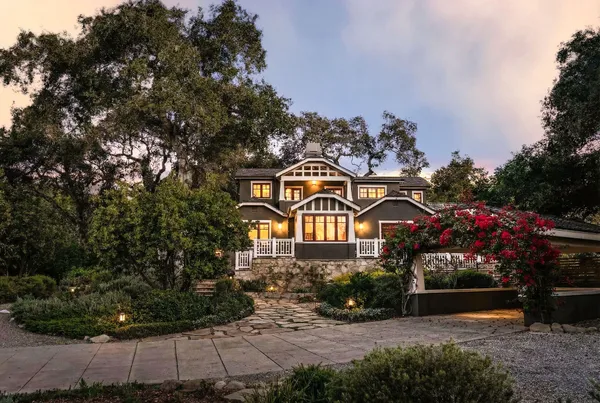 a front view of a house with a yard and potted plants