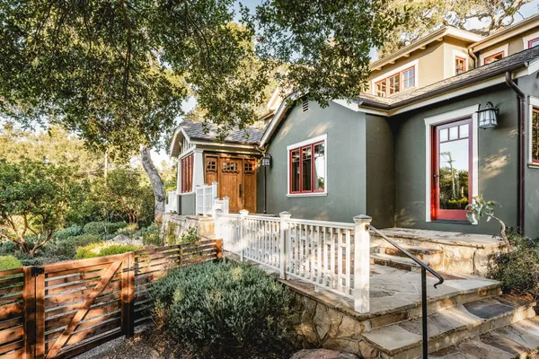 a front view of a house with a tree