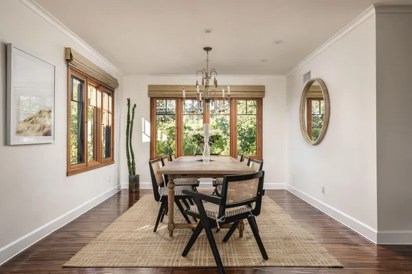 a dining room with furniture a chandelier and wooden floor