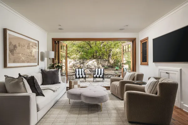 a living room with furniture a large window and a flat screen tv
