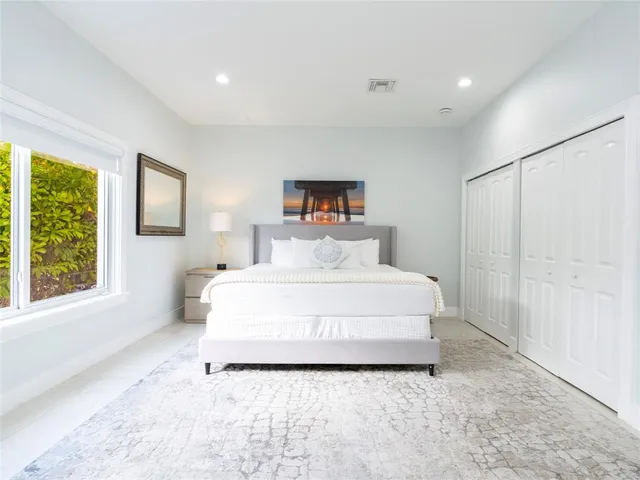 a spacious bedroom with a bed and a flat screen tv