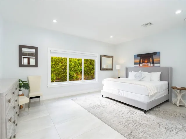 a bedroom with a bed lamps and a large window