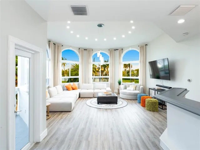 a bedroom with a bed a flat screen tv and a chandelier