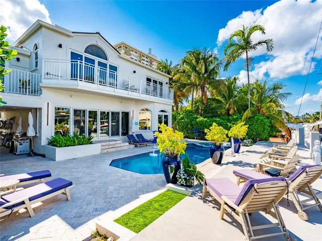 an aerial view of a house with a yard swimming pool and outdoor seating
