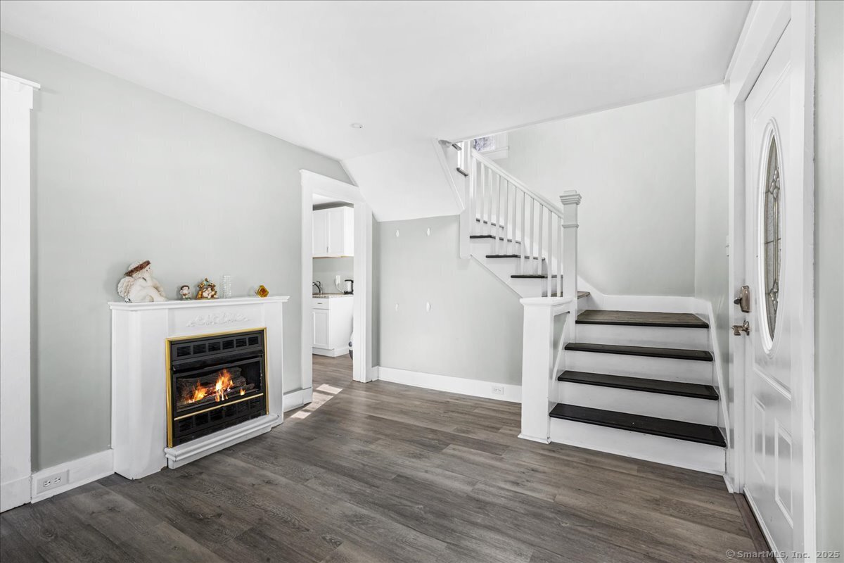55 Raymond Street New London, CT 06320 - Photo 11 of 31 a view of a livingroom with a fireplace stairs and a window