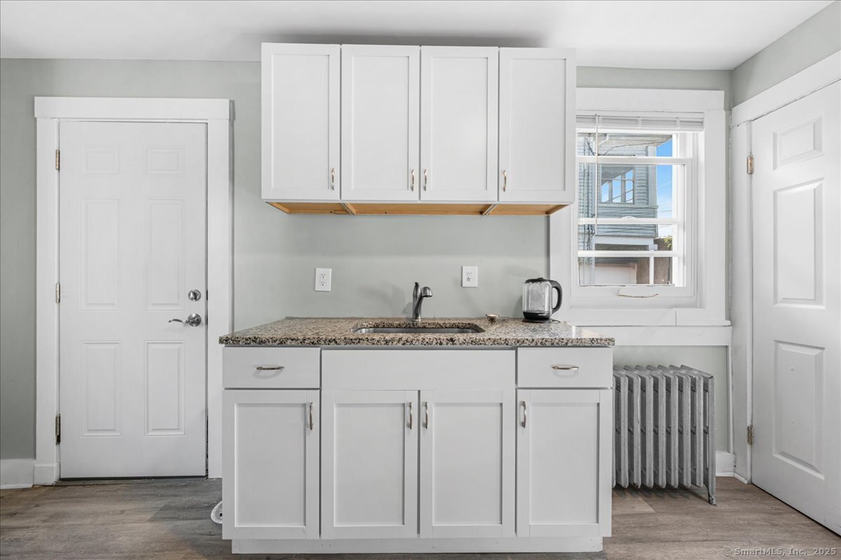 55 Raymond Street New London, CT 06320 - Photo 19 of 31 a kitchen with white cabinets and sink