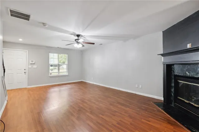 a view of an empty room with a fireplace and a window
