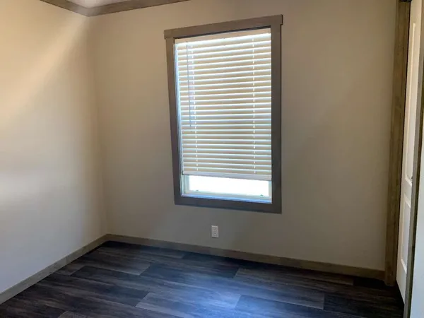 an empty room with wooden floor and a window