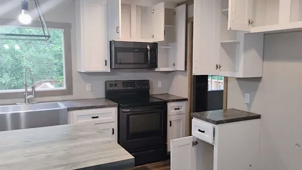 a kitchen with stainless steel appliances granite countertop a stove a sink and a microwave