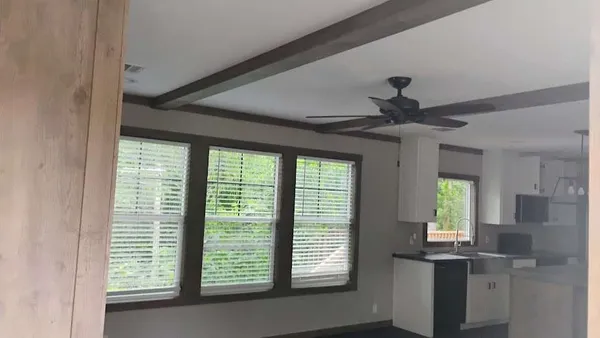 a view of an empty room with window and cabinet