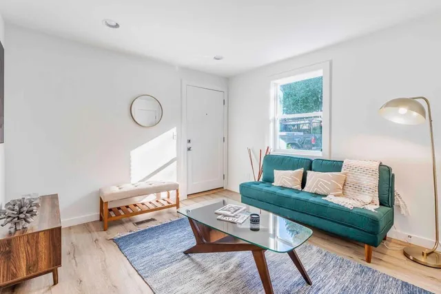 a living room with furniture and wooden floor