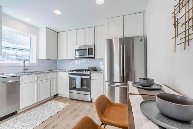 a kitchen with stainless steel appliances granite countertop a refrigerator stove microwave and sink