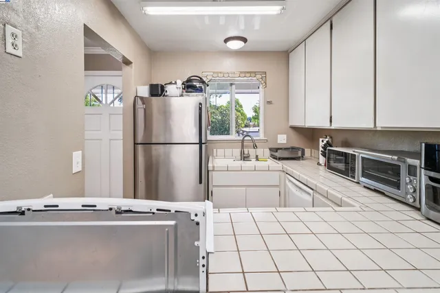 a kitchen with stainless steel appliances a refrigerator sink and cabinets