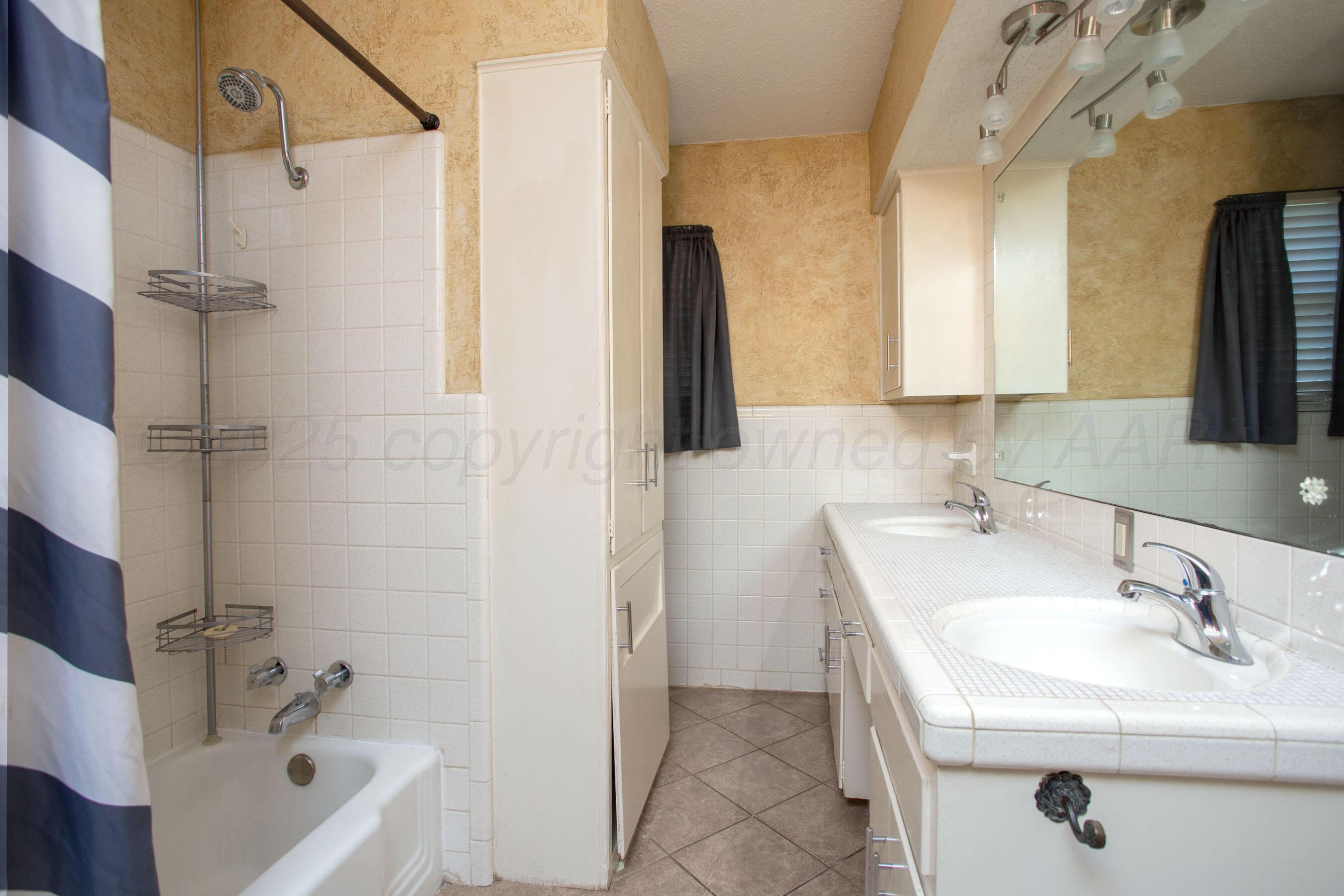 3729 Wayne Street Amarillo, TX 79109 - Photo 25 of 30 a bathroom with a sink a mirror and a bathtub