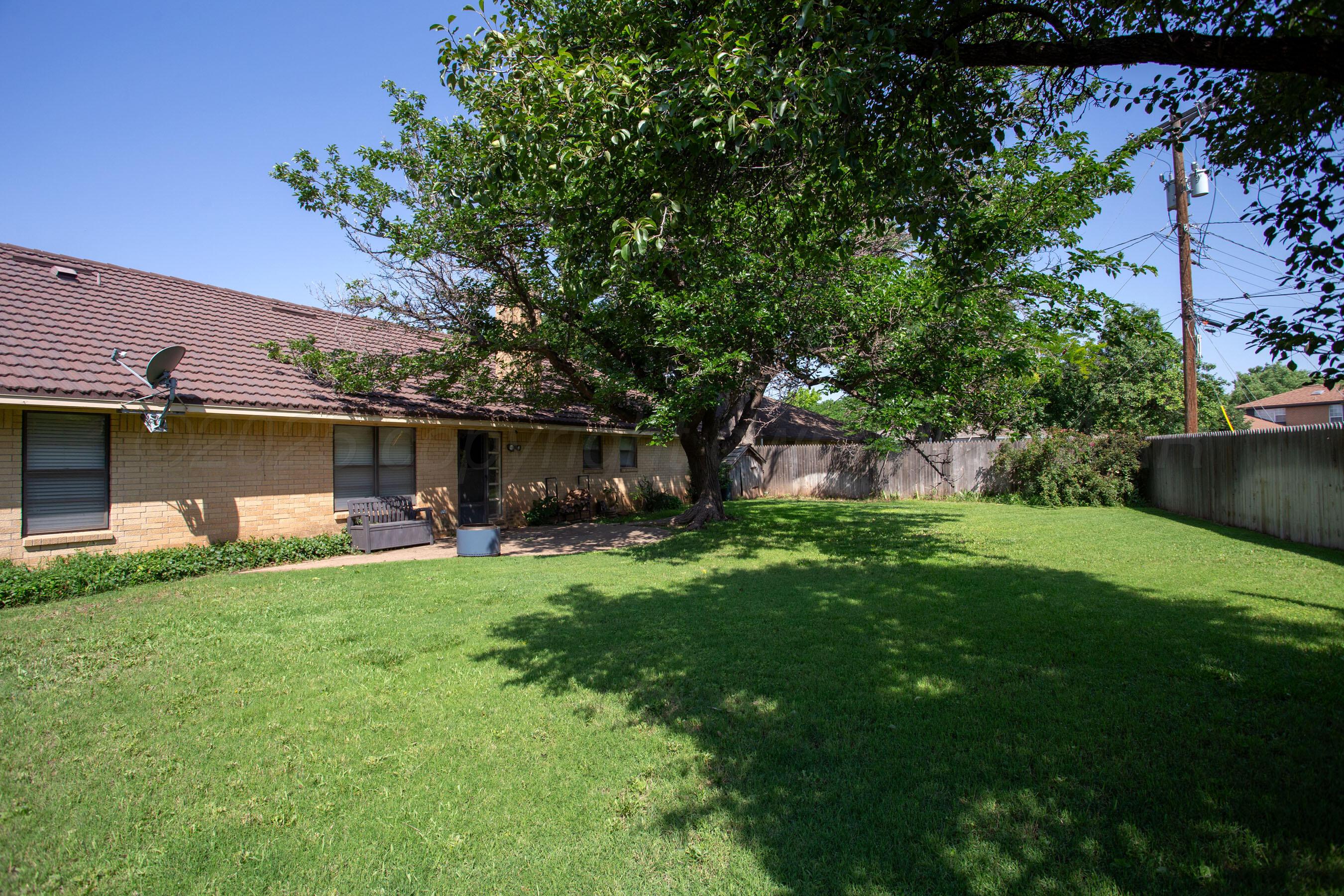 3729 Wayne Street Amarillo, TX 79109 - Photo 29 of 30 a view of a backyard with table and chairs potted plants and a large tree