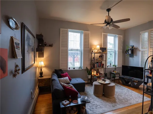 a living room with furniture a window and a flat screen tv