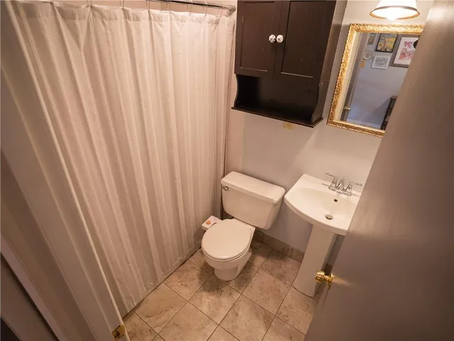 a white toilet sitting next to a shower curtain
