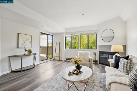 a living room with furniture two window and wooden floor