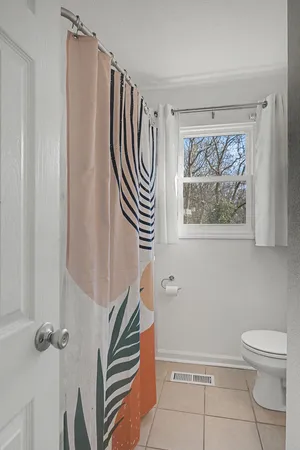 a bathroom with a toilet a sink and a window