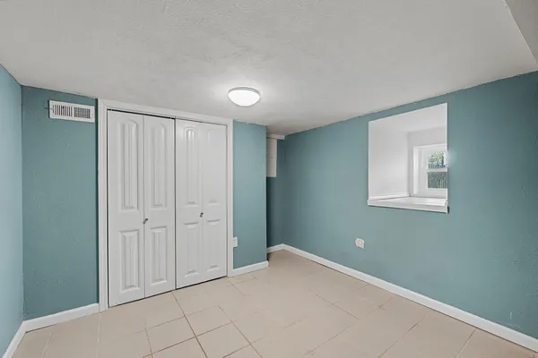 an empty room with fireplace and windows