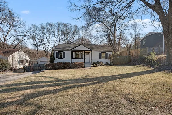 a front view of a house with a yard and trees