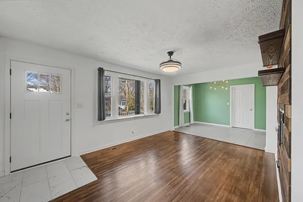 a view of a hallway with a chandelier fan and refrigerator