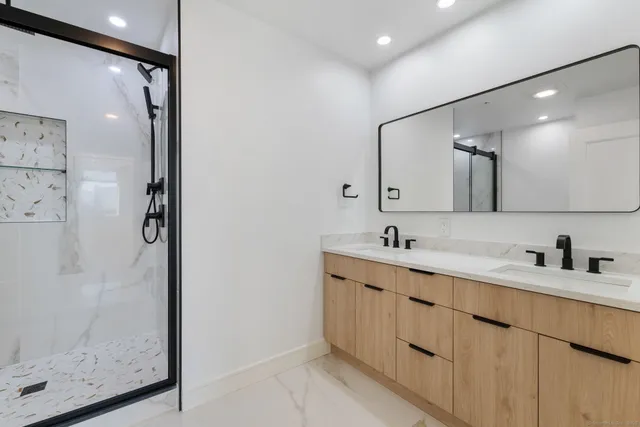 a bathroom with a double vanity sink mirror and shower